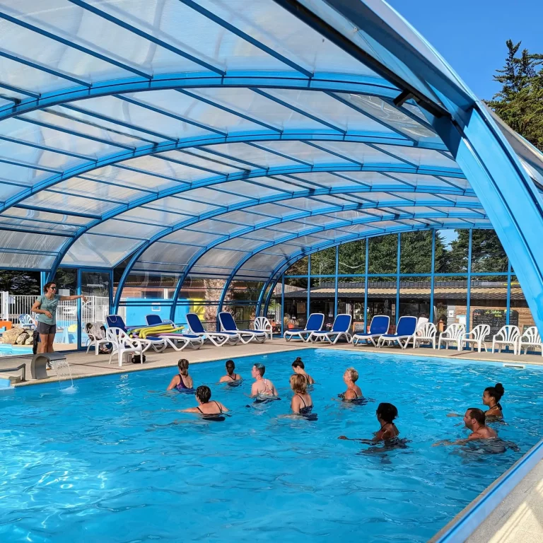 Séance d'aquagym tonique en groupe dans le grand bassin pendant la saison estivale.